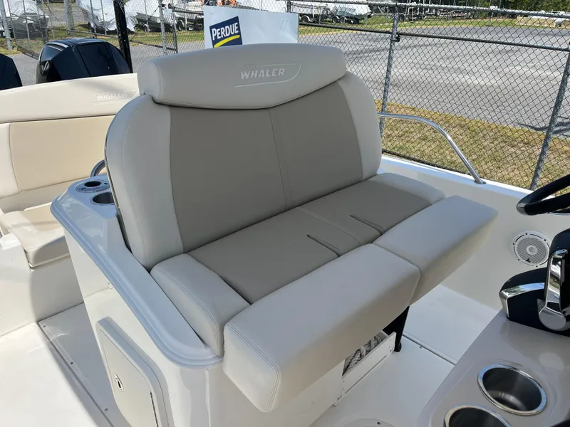 Slide: The Image of 2022 Boston Whaler 270 Dauntless boat seat, gray upholstery, cup holders, outdoor setting. - 18