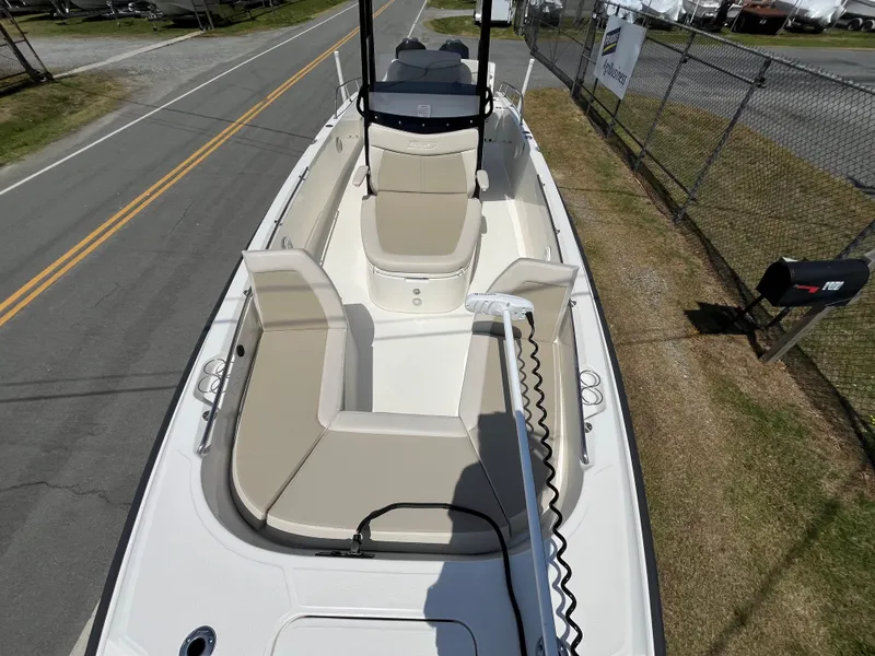 Slide: The Image of 2022 Boston Whaler 270 Dauntless boat with beige seating, docked near a road and fence. - 2