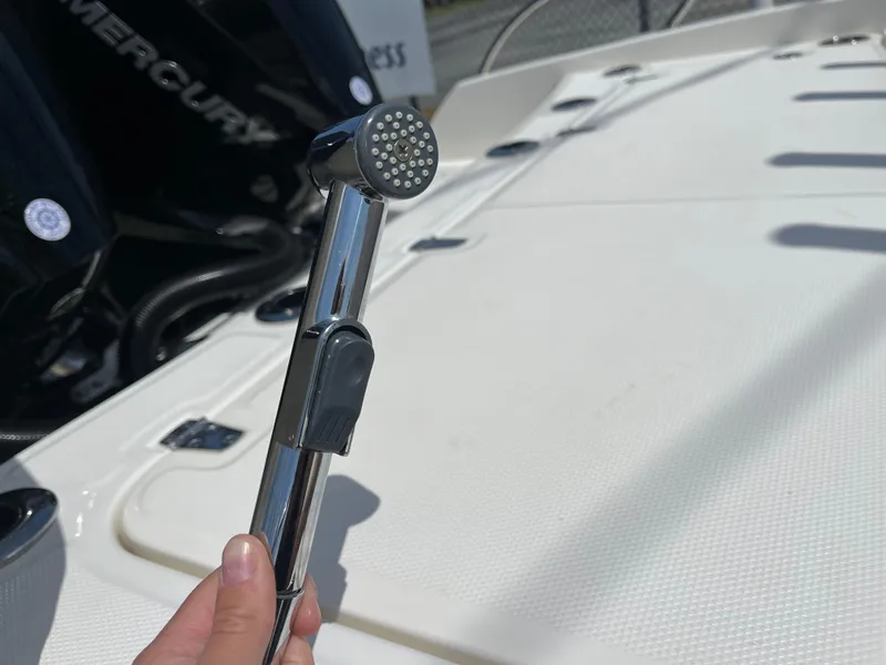 Slide: The Image of Hand holding a showerhead on a 2022 Boston Whaler 270 Dauntless boat deck. - 24