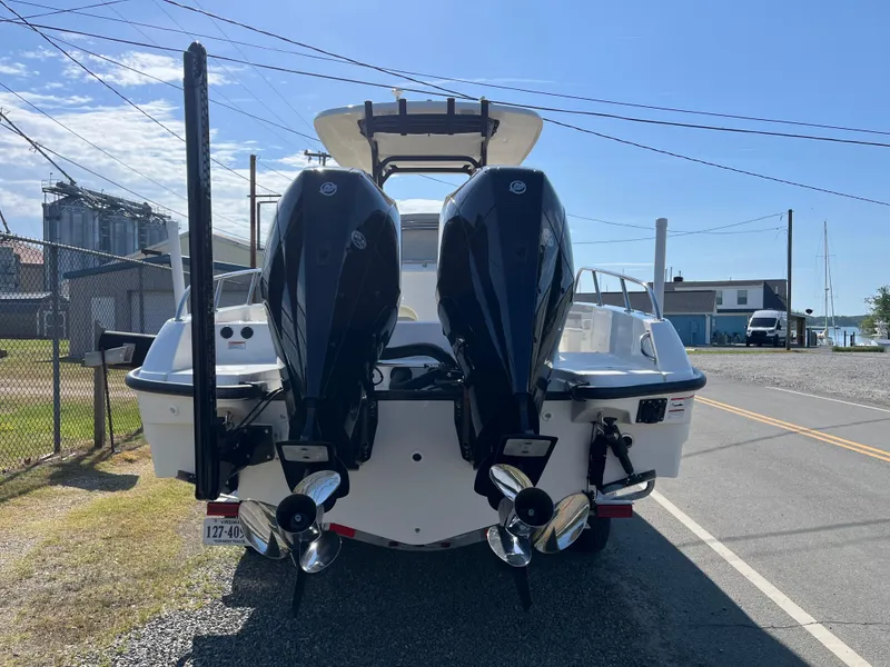 Slide: The Image of 2022 Boston Whaler 270 Dauntless with dual outboard engines, parked on a sunny street. - 28