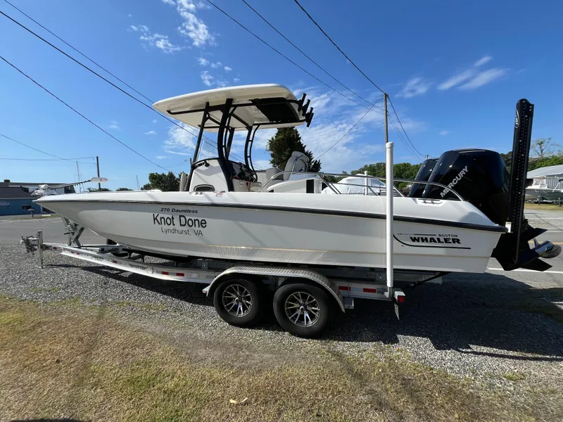 Slide: The Image of 2022 Boston Whaler 270 Dauntless boat on trailer under clear blue sky. - 29