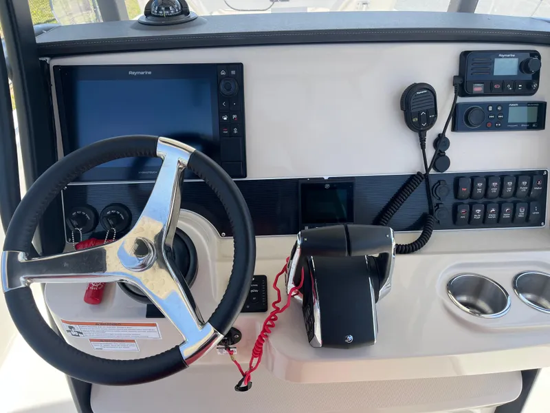 Slide: The Image of 2022 Boston Whaler 270 Dauntless helm with steering wheel, controls, and navigation equipment. - 3