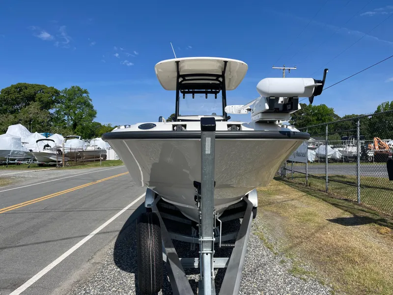 Slide: The Image of 2022 Boston Whaler 270 Dauntless boat on trailer, parked near a road under clear blue sky. - 30