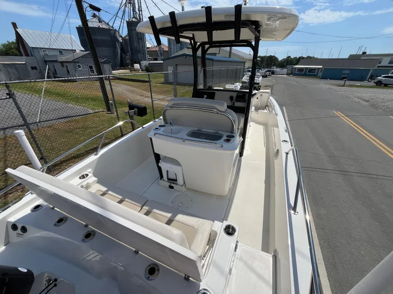 Slide: The Image of 2022 Boston Whaler 270 Dauntless boat with spacious deck and seating, docked near industrial area. - 4