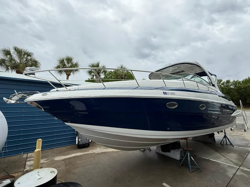 Slide: The Image of 2019 Crownline 350 SY boat on dry dock, blue hull, overcast sky. - 13