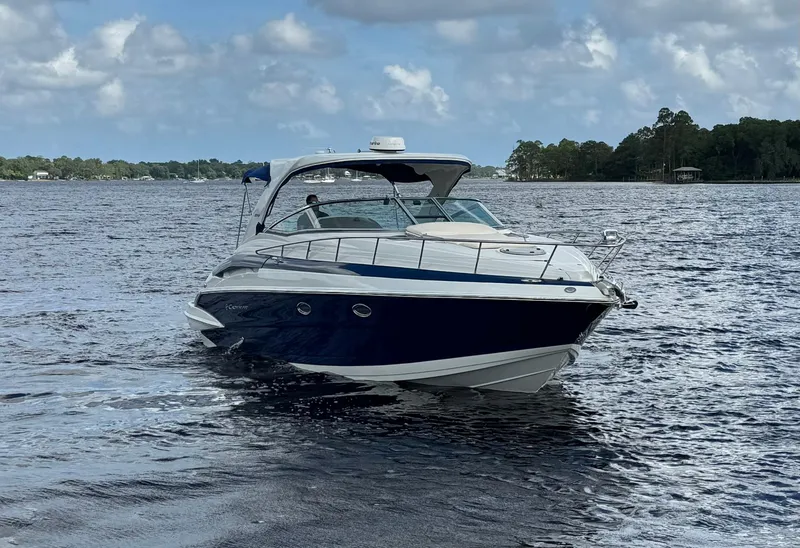 Slide: The Image of 2019 Crownline 350 SY boat cruising on a lake under cloudy skies. - 2