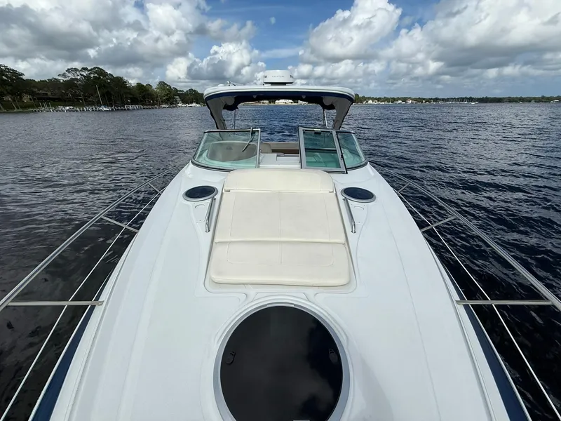 Slide: The Image of 2019 Crownline 350 SY yacht on calm water under cloudy sky. - 26