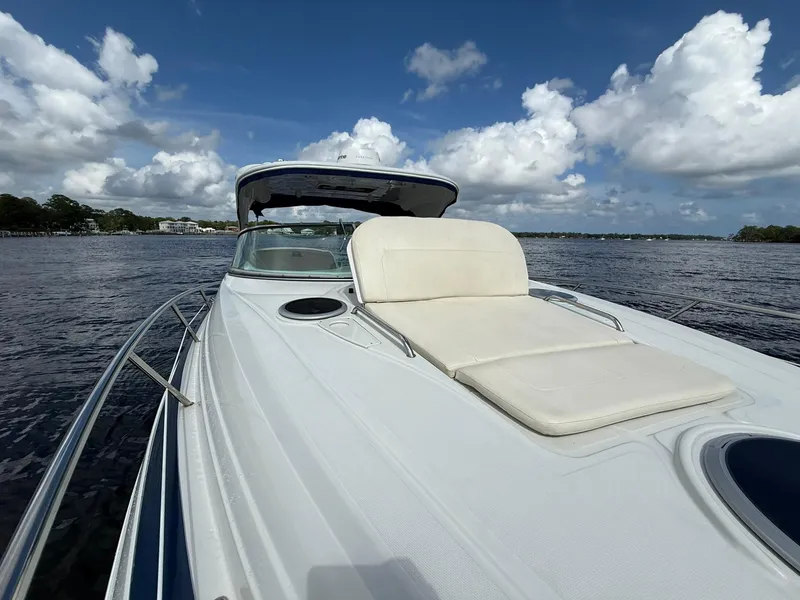 Slide: The Image of 2019 Crownline 350 SY yacht with sunbed on deck, cruising under a partly cloudy sky. - 27
