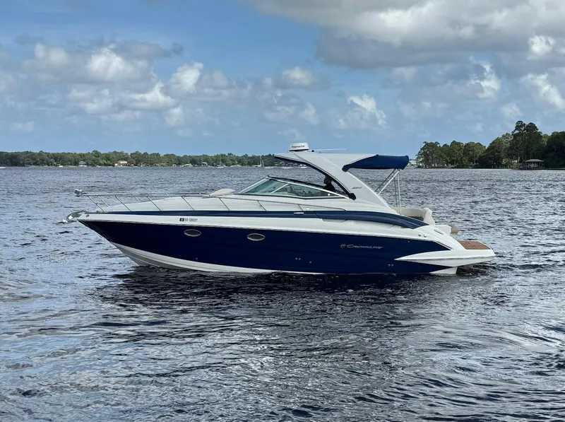 Slide: The Image of 2019 Crownline 350 SY boat on a calm lake under a cloudy sky. - 3