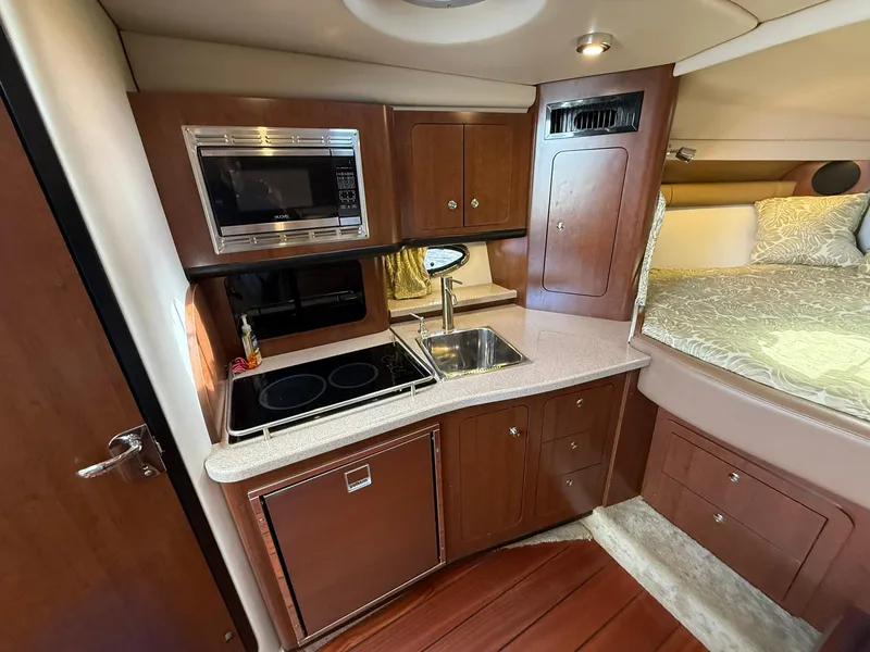 Slide: The Image of 2019 Crownline 350 SY yacht interior with kitchenette and bed. - 38