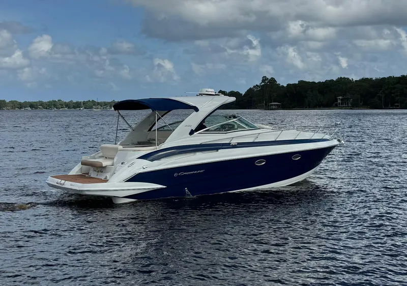 Slide: The Image of 2019 Crownline 350 SY boat cruising on a lake under cloudy skies. - 4