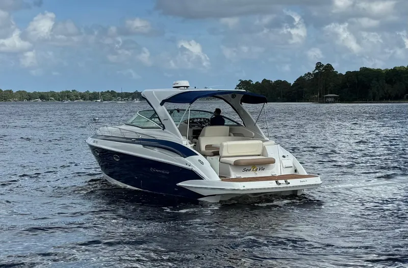 Slide: The Image of 2019 Crownline 350 SY boat cruising on a lake under cloudy skies. - 5