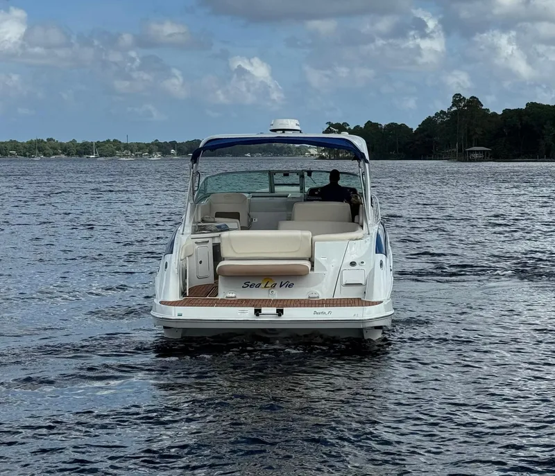 Slide: The Image of 2019 Crownline 350 SY boat on water, rear view, cloudy sky. - 6
