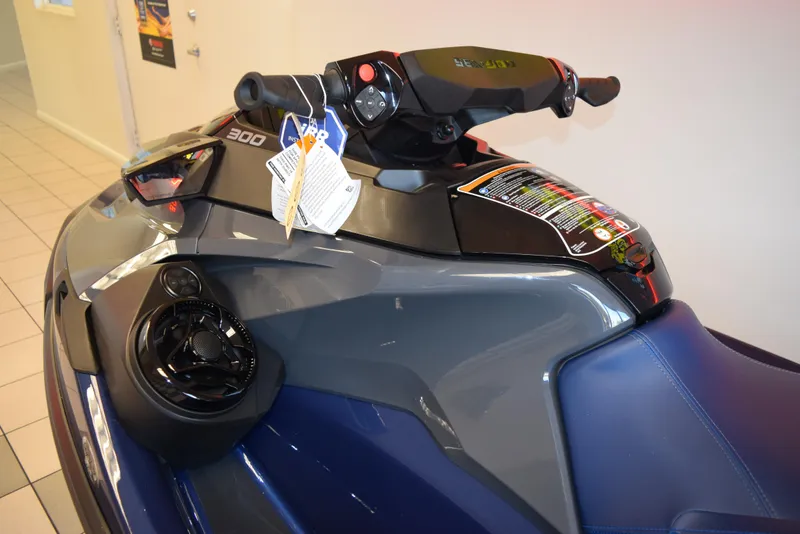 Slide: The Image of 2024 Sea-Doo GTX 300 jet ski, close-up of handlebars and seat in showroom. - 6