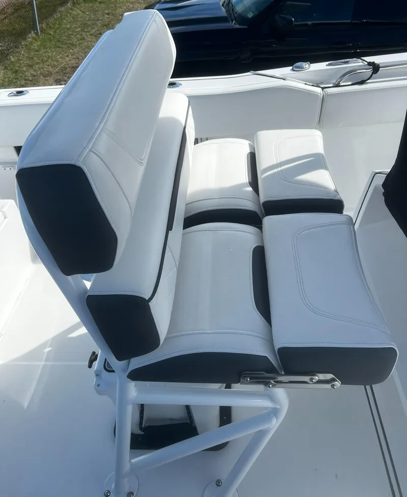 Slide: The Image of 2022 Blackfin 222 CC boat seating with white and black cushioned design. - 17