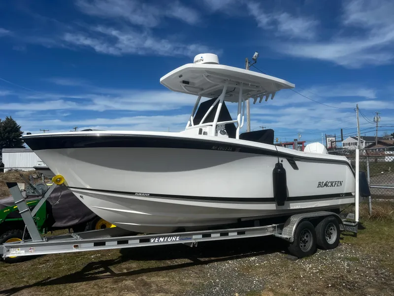 Slide: The Image of 2022 Blackfin 222 CC boat on trailer under clear blue sky. - 3