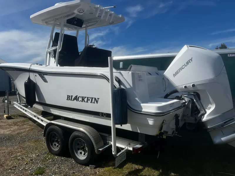 Slide: The Image of 2022 Blackfin 222 CC boat on trailer with Mercury engine, parked outdoors. - 4