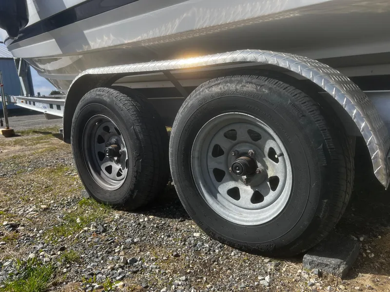 Slide: The Image of Trailer wheels of a 2022 Blackfin 222 CC boat on gravel surface. - 42