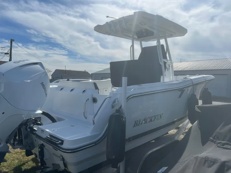Slide: The Image of 2022 Blackfin 222 CC boat with outboard motor, docked under a cloudy sky. - 5