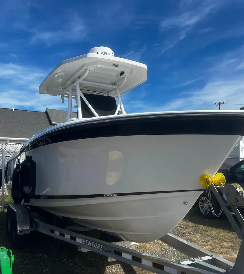 Slide: The Image of 2022 Blackfin 222 CC boat on trailer under clear blue sky. - 6