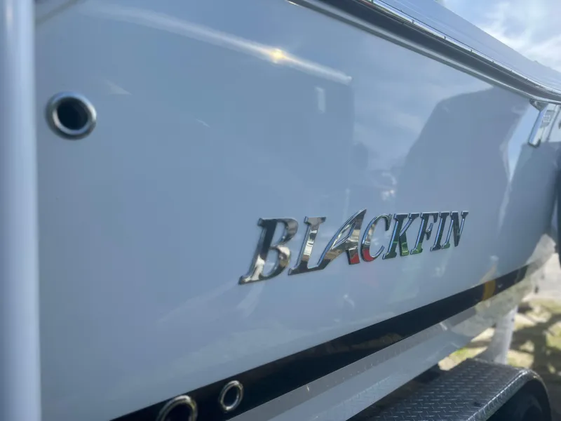 Slide: The Image of 2022 Blackfin 222 CC boat, close-up of logo on sleek white hull. - 7