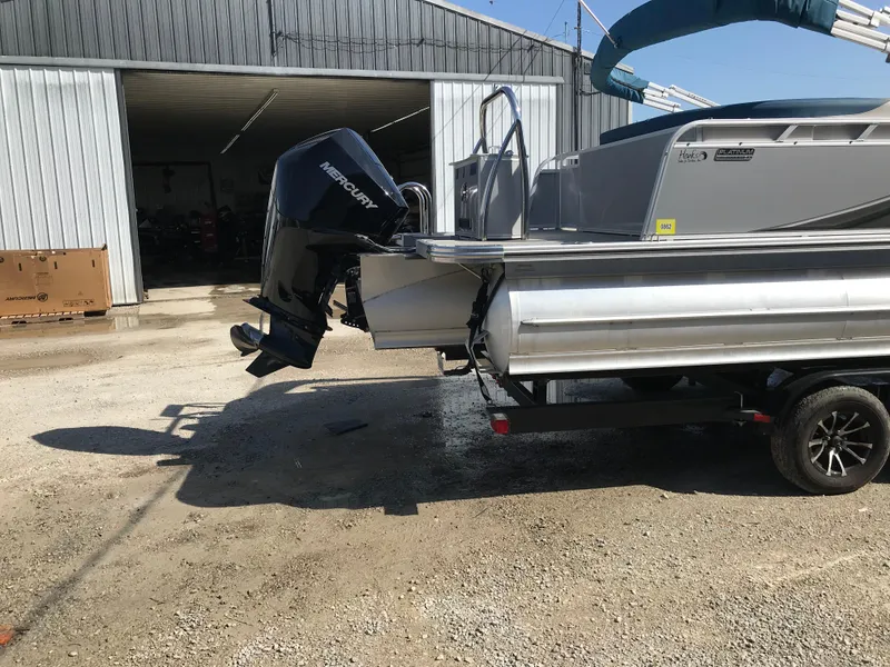 Slide: The Image of 2023 Avalon LSZ Elite Windshield boat on trailer outside a garage. - 11