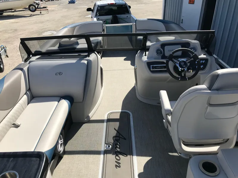 Slide: The Image of 2023 Avalon LSZ Elite Windshield boat interior with steering wheel and seating. - 20