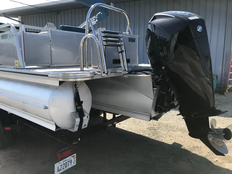 Slide: The Image of 2023 Avalon LSZ Elite Windshield pontoon boat with powerful outboard motor, parked outdoors. - 7