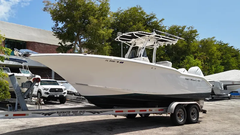 Slide: The Image of 2024 Key West 244 CC boat on trailer, parked outdoors under clear sky. - 1
