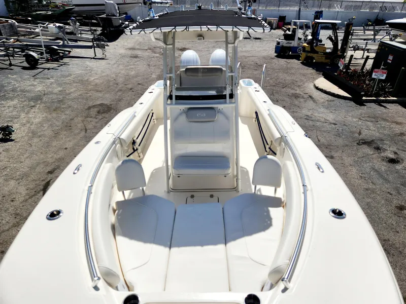 Slide: The Image of 2024 Key West 244 CC boat with spacious deck and seating, docked outdoors. - 11