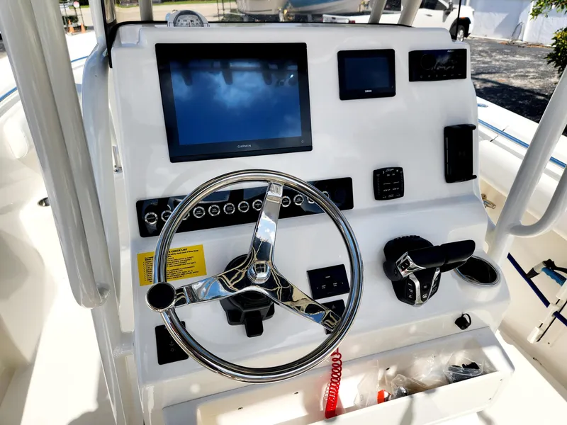 Slide: The Image of 2024 Key West 244 CC boat dashboard with steering wheel and electronic displays. - 13