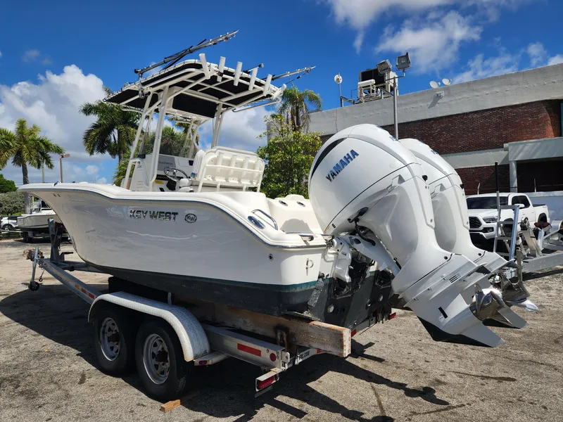 Slide: The Image of 2024 Key West 244 CC boat on trailer with Yamaha engine, parked outdoors. - 2