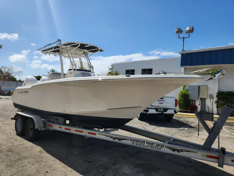 Slide: The Image of 2024 Key West 244 CC boat on trailer, parked outdoors under a clear blue sky. - 4