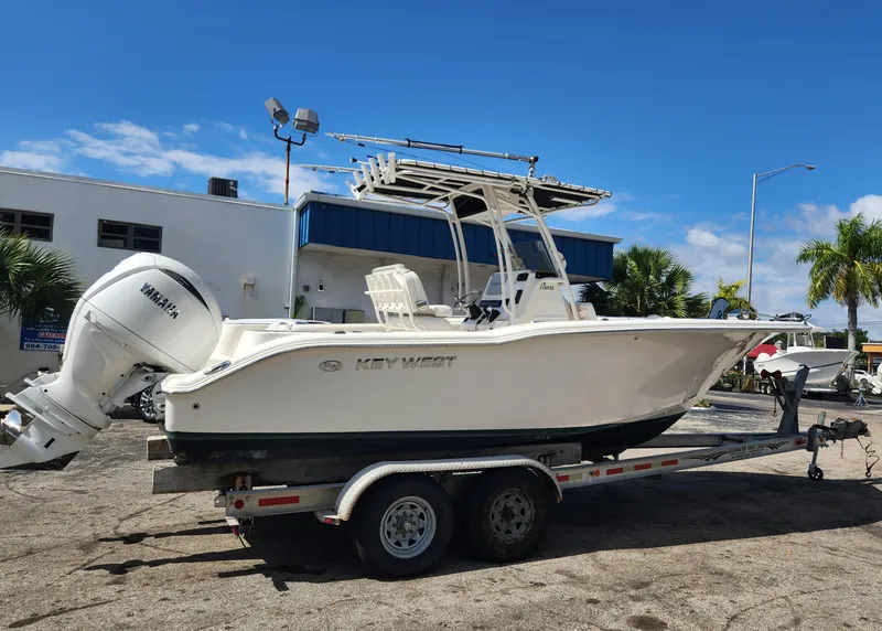 Slide: The Image of 2024 Key West 244 CC boat on trailer, parked outdoors under clear blue sky. - 5