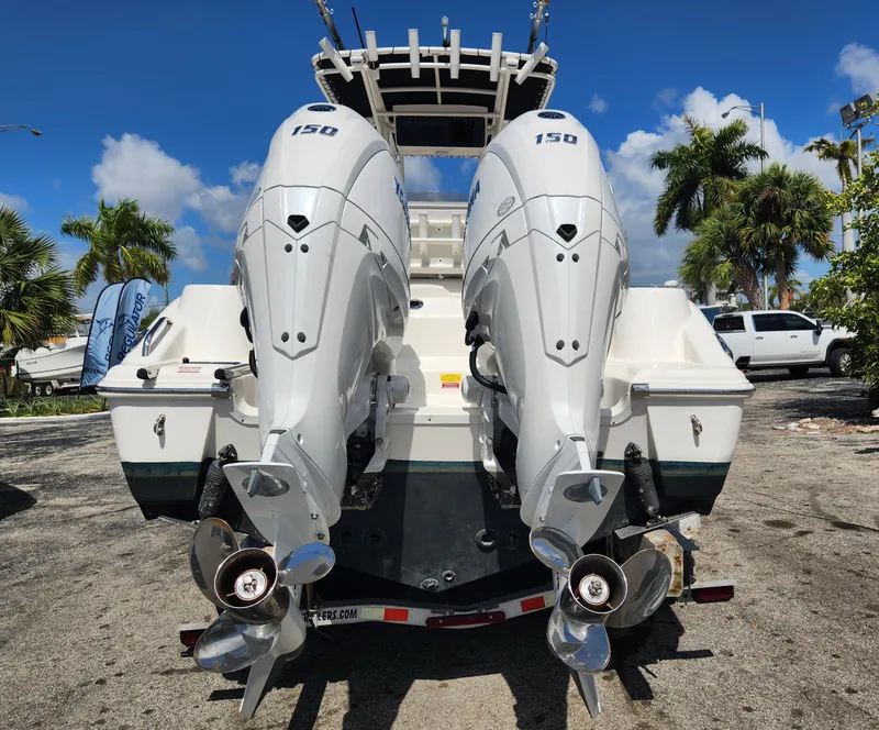 Slide: The Image of 2024 Key West 244 CC boat with dual outboard engines, parked outdoors. - 6