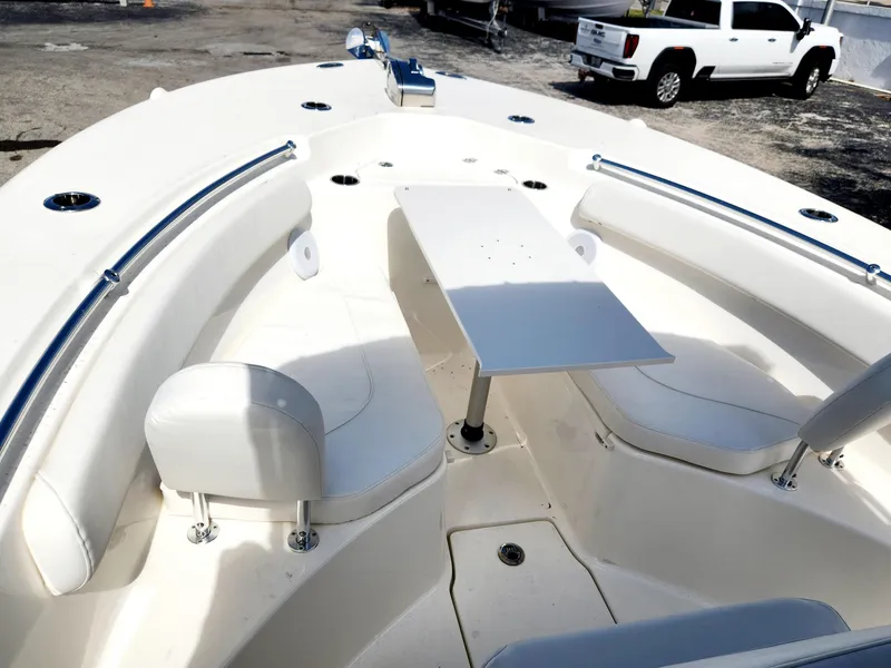 Slide: The Image of 2024 Key West 244 CC boat interior with seating and table, parked near a white truck. - 7