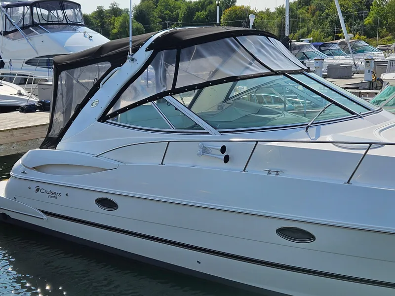 Slide: The Image of 2004 Cruisers Yachts 340 Express docked at marina, featuring sleek design and black canopy. - 11