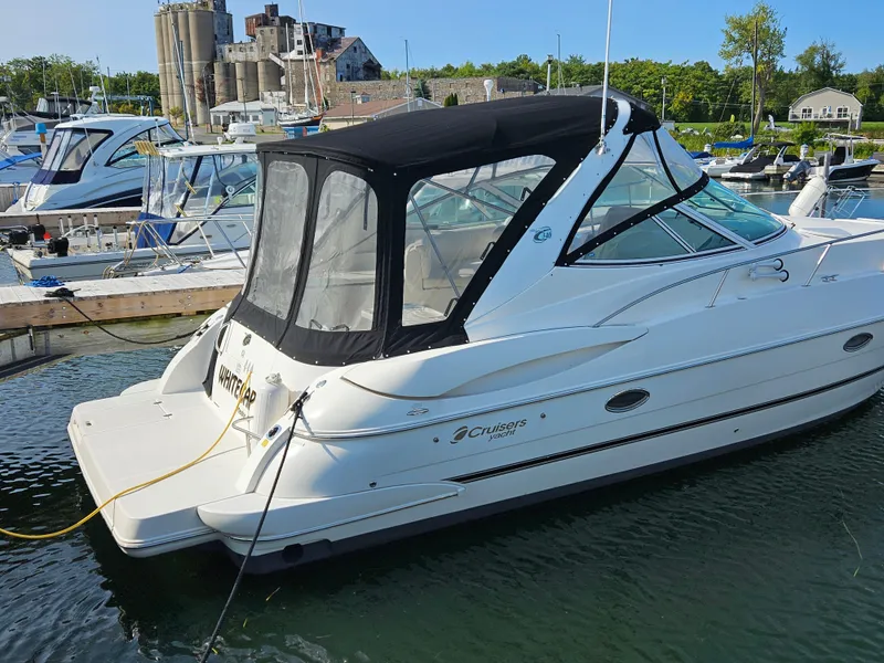 Slide: The Image of 2004 Cruisers Yachts 340 Express docked in a marina, featuring sleek design and black canopy. - 12