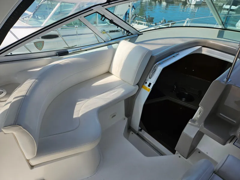 Slide: The Image of 2004 Cruisers Yachts 340 Express interior with white seating and cabin entrance. - 16