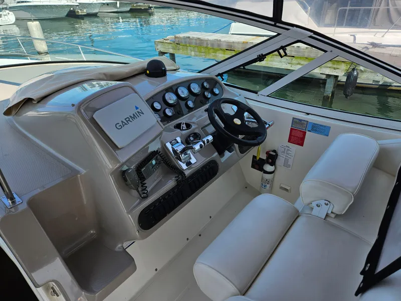 Slide: The Image of 2004 Cruisers Yachts 340 Express helm with Garmin navigation, docked by the water. - 17