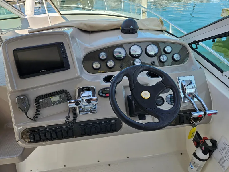 Slide: The Image of 2004 Cruisers Yachts 340 Express helm with steering wheel, gauges, and controls. - 18