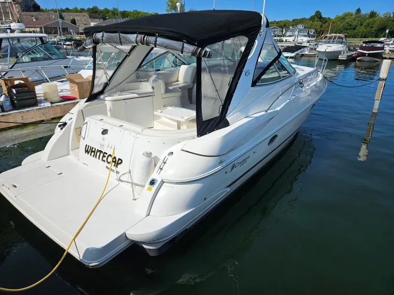 Slide: The Image of 2004 Cruisers Yachts 340 Express boat docked in marina, featuring sleek design and black canopy. - 2