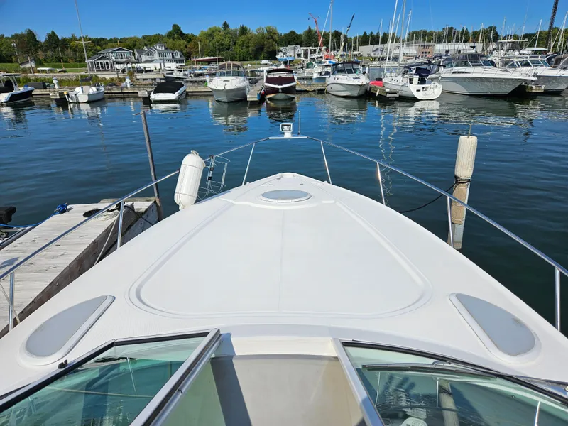 Slide: The Image of 2004 Cruisers Yachts 340 Express docked in a marina with other boats. - 21