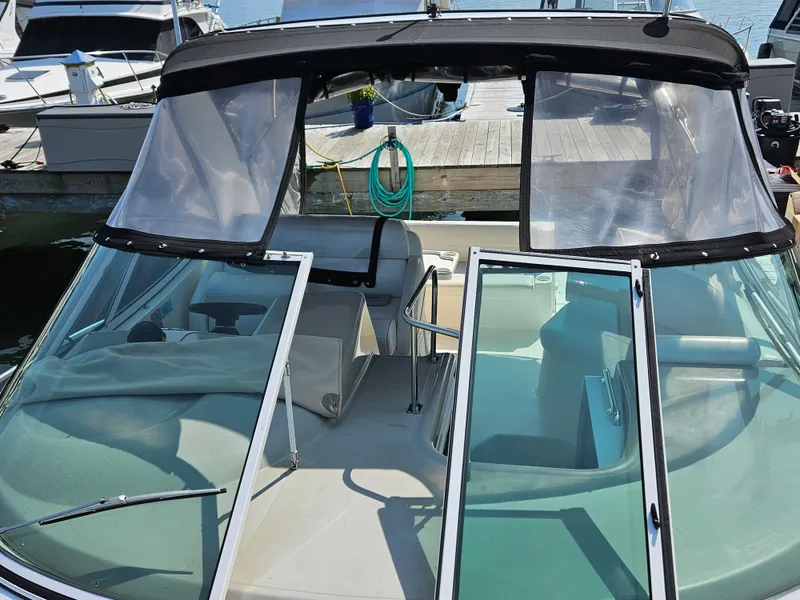 Slide: The Image of 2004 Cruisers Yachts 340 Express boat docked, featuring open cockpit and windshield. - 22
