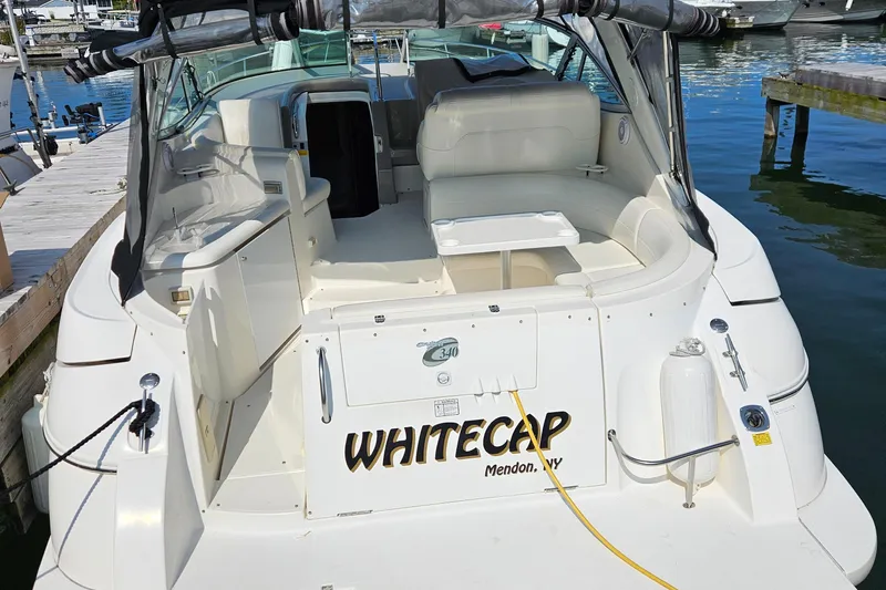 Slide: The Image of 2004 Cruisers Yachts 340 Express docked, featuring spacious seating and "Whitecap" name on stern. - 25