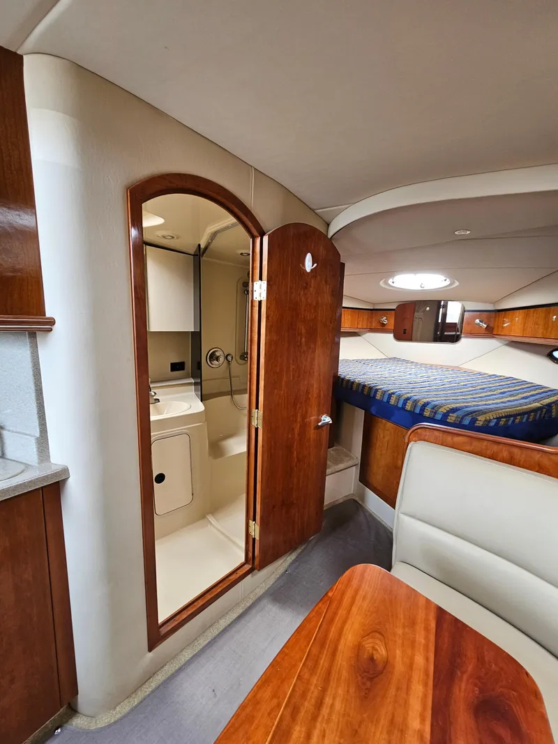 Slide: The Image of 2004 Cruisers Yachts 340 Express interior with bed, bathroom, and dining area. - 29
