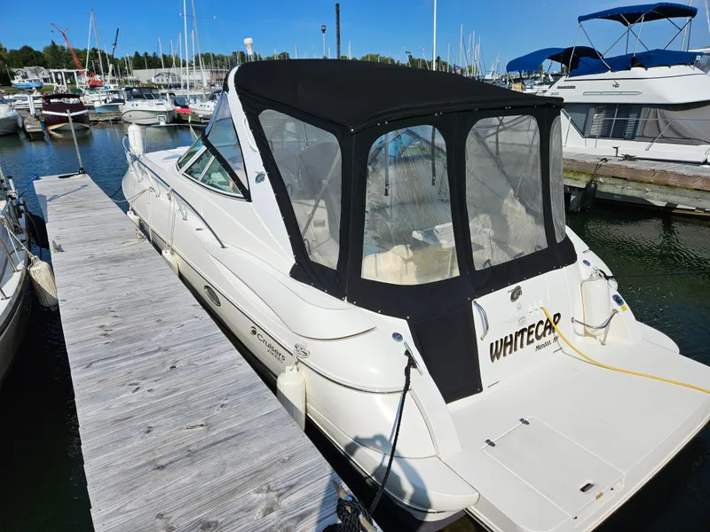 Slide: The Image of 2004 Cruisers Yachts 340 Express docked at marina, featuring sleek design and black canopy. - 3