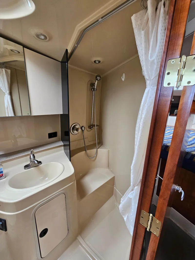 Slide: The Image of 2004 Cruisers Yachts 340 Express bathroom with shower, sink, and mirror. - 31