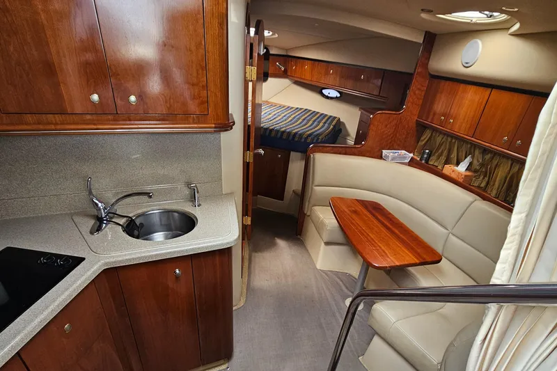 Slide: The Image of 2004 Cruisers Yachts 340 Express interior with kitchenette, seating area, and cozy sleeping quarters. - 35