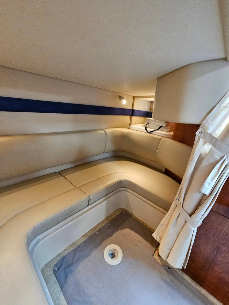Slide: The Image of 2004 Cruisers Yachts 340 Express cabin interior with beige seating and curtains. - 38